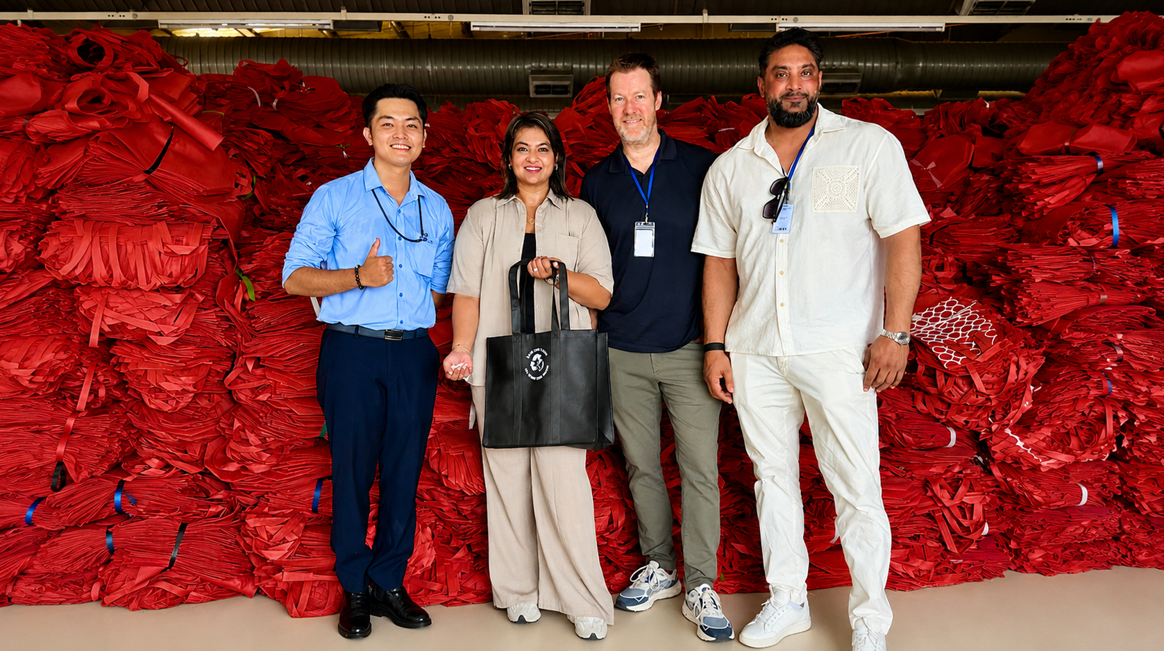 Waste2Wear and Kwality Holdings representatives at the Waste2Wear manufacturing facility with recycled material in the background
